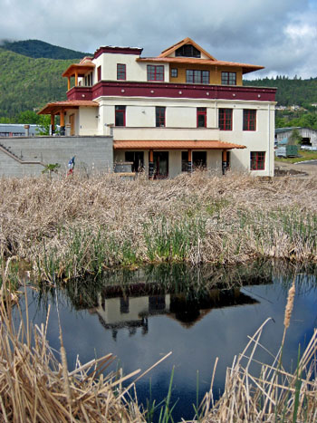 Kagyu Sukha Chöling's newly completed Meditation Center in Ashland, Oregon.  Wetland and wildlife pond are in foreground.  Main entry to the building is at left.