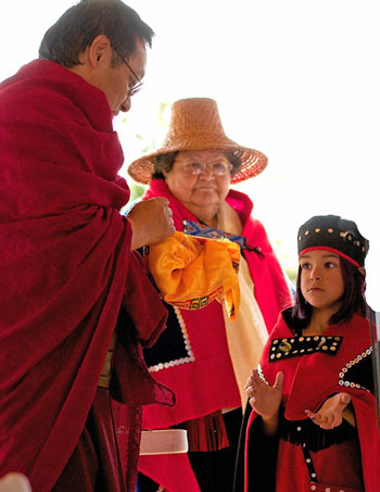 A child offers Gangteng Rinpoche a handmade rattle as a gift.